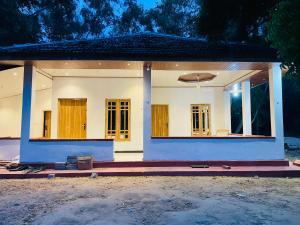 a home with a blue and white at Lotus Green Hotel And Restaurant in Arugam Bay