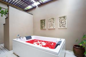 a white bath tub filled with red liquid at Villa Semana Resort & Spa in Ubud +94 photos