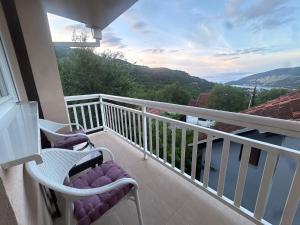 a balcony with two chairs and a view of the mountains at Volga in Herceg-Novi