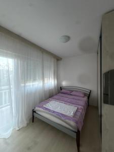 a bed in a white room with a window at Volga in Herceg-Novi