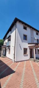 a large white building with a red brick courtyard at Elena Haus in Cluj-Napoca