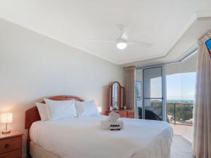 a bedroom with a large white bed and a window at Points North Unit 507 - Caloundra in Caloundra
