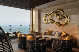 a lobby with chairs and a couch and a mirror at Trans Hotel Jakarta in Cibubur