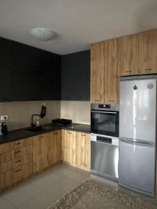 a kitchen with a stainless steel refrigerator and wooden cabinets at Volga in Herceg-Novi +3 photos
