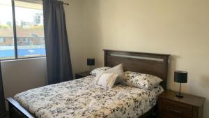 a bedroom with a bed and a window at Beachside Court Unit 9 in Caloundra +4 photos