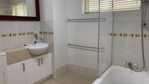 a bathroom with a glass shower and a sink at Beachside Court Unit 9 in Caloundra