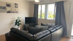a living room with a leather couch and a television at Beachside Court Unit 9 in Caloundra
