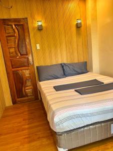 ein Bett in einem Zimmer mit einer Holzwand in der Unterkunft Pines View in Kayagan