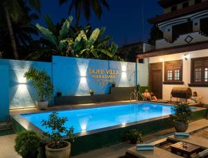 a swimming pool in front of a house at night at Sajee Villa in Hikkaduwa