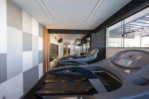 a row of treadmills in a gym with a row of treadms at Victory Suites in Juiz de Fora