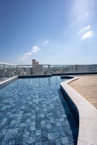 a swimming pool on the roof of a building at Victory Suites in Juiz de Fora