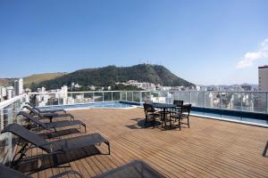 a deck with chairs and a table on a balcony at Victory Suites in Juiz de Fora