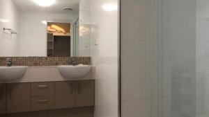 a bathroom with two sinks and a mirror at Unit 33 Outlook Caloundra - Stunning Views! in Caloundra