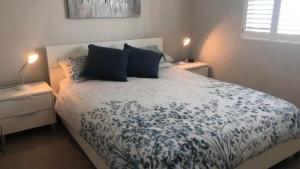 a bedroom with a bed with blue and white sheets and pillows at Unit 33 Outlook Caloundra - Stunning Views! in Caloundra