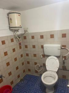 a bathroom with a toilet and a water tank at ROYAL budget Rooms in Ooty