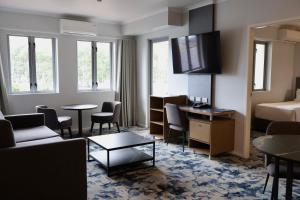 a hotel room with a bed and a living room at Brisbane International Virginia in Brisbane