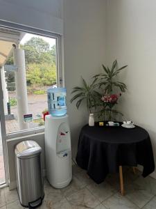 a room with a table and a machine next to a window at Seaside Garden Hotel in Wamberal