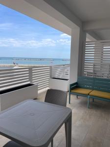 a balcony with a view of the ocean and a bench at Sumus Smart Residence in Porto SantʼElpidio