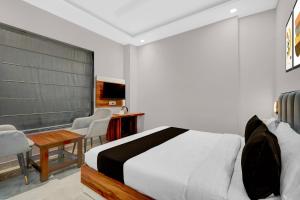 a bedroom with a bed and a table and chairs at Collection O Kharar Bus Terminal Formerly Hotel Kamboj in Kharar +24 photos