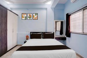 a bedroom with a large white bed and a window at Hotel O Satara Bypass Formerly Sairaj Lodging in Satara