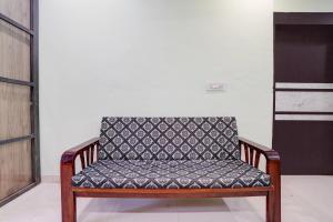 a wooden bench with a black and white seat at Hotel O Satara Bypass Formerly Sairaj Lodging in Satara
