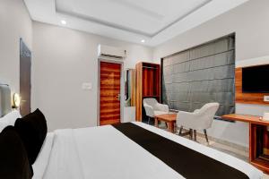 a bedroom with a bed and a table and chairs at Collection O Kharar Bus Terminal Formerly Hotel Kamboj in Kharar