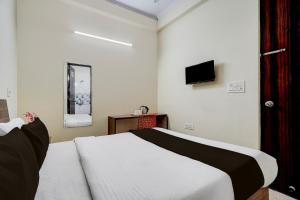 a bedroom with a bed and a tv on the wall at Hotel O Railway Station Road Formerly Alwar Delight in Alwar