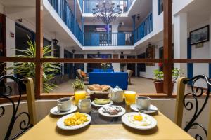a table with food on it with orange juice at SAN BLAS PLAZA INn in Cusco