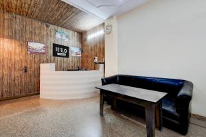 a black leather couch and a table in a room at Hotel O Railway Station Road Formerly Alwar Delight in Alwar