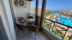 a balcony with a table and chairs and a view of a pool at بانوراما in Zāwiyat ‘Abd al Mun‘im