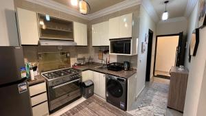 a kitchen with a stove and a dishwasher at بانوراما in Zāwiyat ‘Abd al Mun‘im