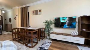 a living room with a table and a tv on a wall at بانوراما in Zāwiyat ‘Abd al Mun‘im