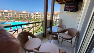 a balcony with chairs and a table and a pool at بانوراما in Zāwiyat ‘Abd al Mun‘im