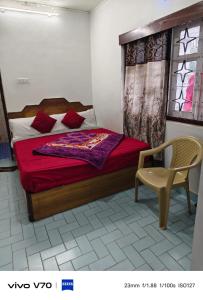a bedroom with a bed and a chair in it at ROYAL budget Rooms in Ooty