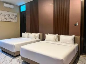 two beds sitting next to each other in a room at Acasa Cottage by Samsara in Cipaok