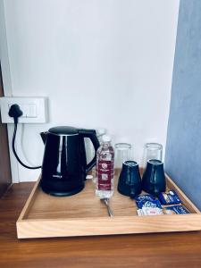 a wooden tray with a tea kettle and some drinks at Dreamwagon hotel lakkidi in Vythiri