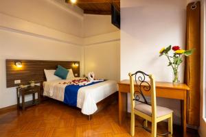 a bedroom with a bed and a desk and a chair at SAN BLAS PLAZA INn in Cusco
