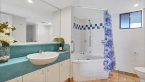 a bathroom with a sink and a tub and a shower at #812 Ramada Resort, Beachfront in Golden Beach