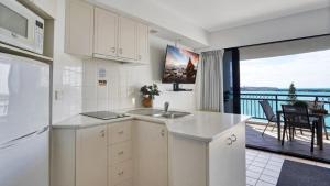 a white kitchen with a view of a balcony at #812 Ramada Resort, Beachfront in Golden Beach