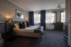 a bedroom with a large bed with black pillows at Central Hotellet Tierp in Tierp +41 photos