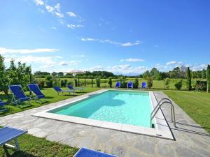 コルトーナにあるBelvilla by OYO Balmy Villa in Cortona with Poolの青いラウンジチェア付きの庭のスイミングプール