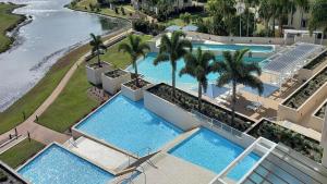 an overhead view of two swimming pools with palm trees at Lovely Studio Apartment Overlooking Golf Course! in Pelican Waters