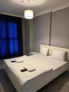 a bedroom with a large white bed with towels on it at CİTY HOME tüyap in Esenyurt +2 photos