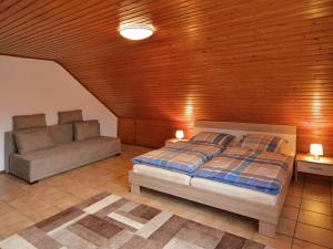 a bedroom with a bed and a couch at Apartment in Assinghausen with a Sun Terrace in Assinghausen