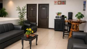 a living room with two couches and a table with flowers at hotel barmel in Siguatepeque