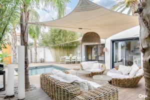 a patio with wicker furniture next to a pool at Plage 200m in Saint-Cyr-sur-Mer