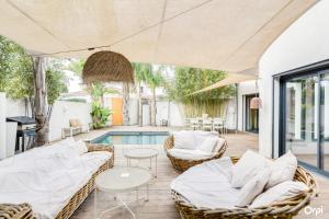 a living room with wicker furniture and a swimming pool at Plage 200m in Saint-Cyr-sur-Mer