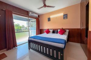 a bedroom with a bed with red pillows and a window at Sancta Maria - Accomodation For Groups -Cochin Airport in Nedumbassery