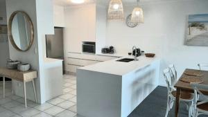 a white kitchen with a counter and a dining room at The Moorings Unit 508 in Golden Beach