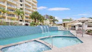 a swimming pool with a waterfall and a building at The Moorings Unit 508 in Golden Beach
